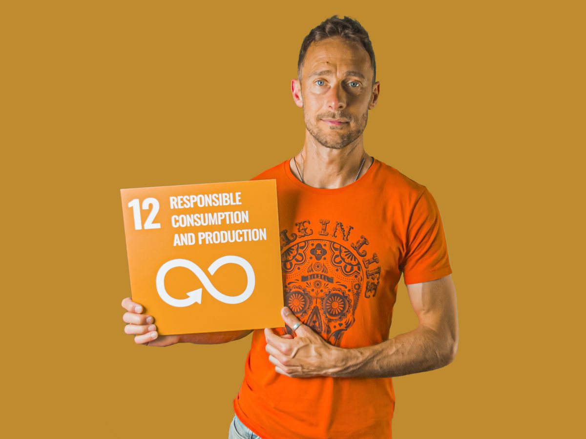 Man holding up sign showing Global Sustainable Development Goal 12, responsible consumption and production.